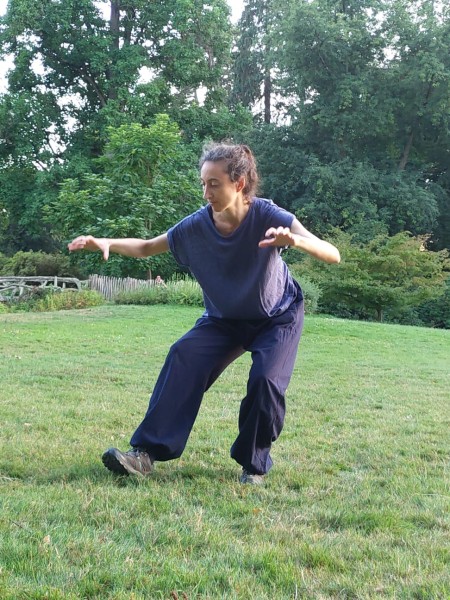 professeure de qi gong pratiquant le mouvement du tigre dans un parc à Genève